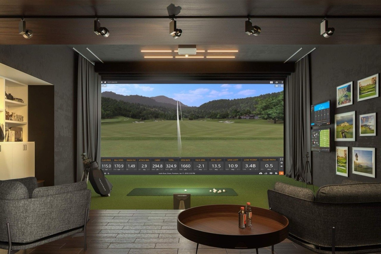 Simulator-Lounge mit Leinwand, Sesseln und TrackMan-Datenanzeige